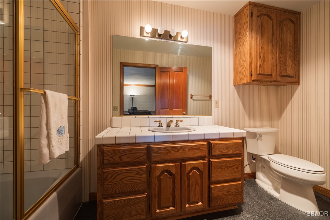 599 Cove Drive Big Bear Lake, CA 92315 - Photo 23 of 50 a bathroom with a sink a toilet and mirror