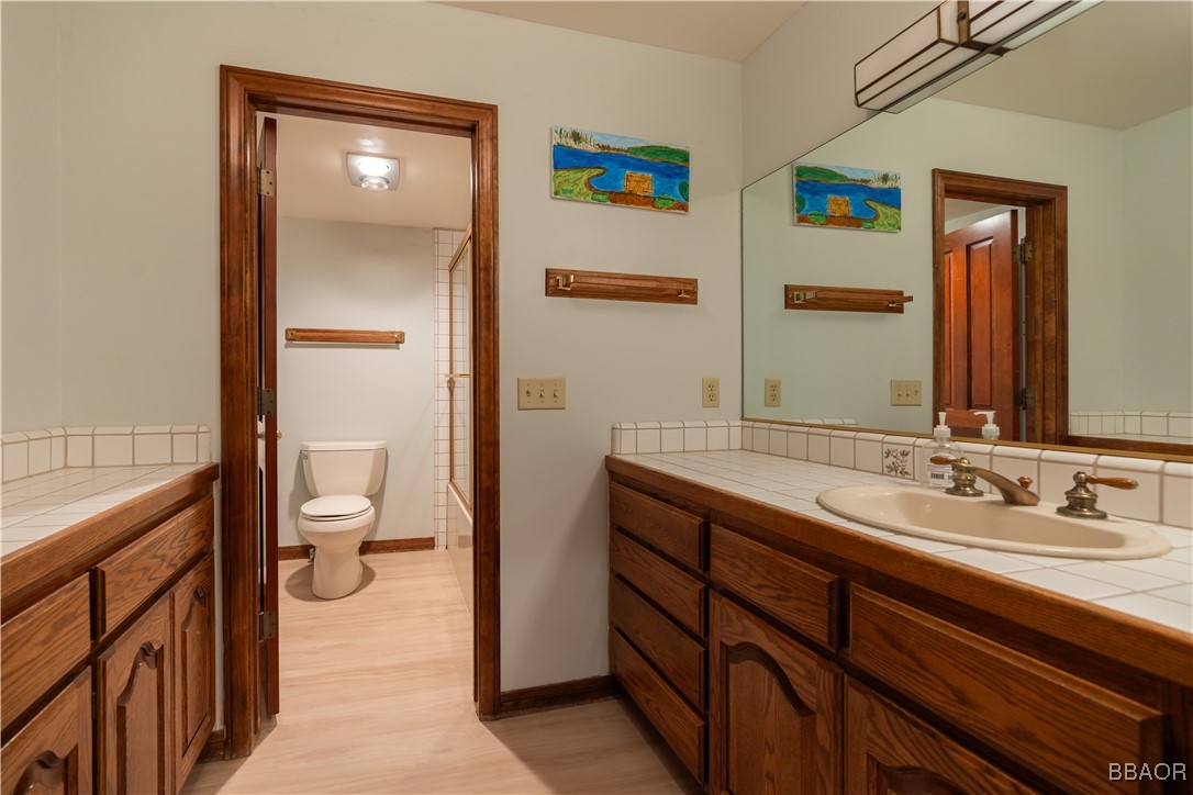 599 Cove Drive Big Bear Lake, CA 92315 - Photo 28 of 50 a spacious bathroom with a granite countertop sink a toilet and a mirror