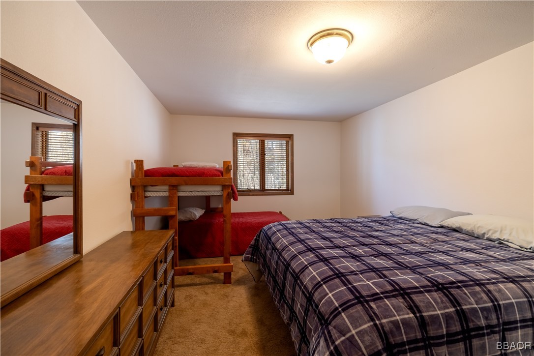 599 Cove Drive Big Bear Lake, CA 92315 - Photo 38 of 50 a bedroom with a bed and wooden floor