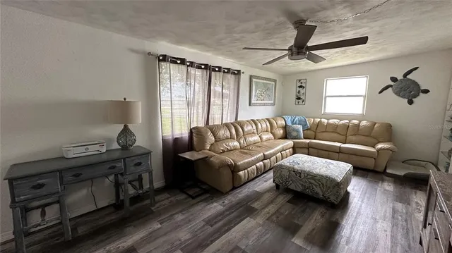 a living room with furniture and a wooden floor