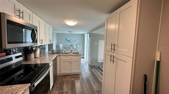 a kitchen with stainless steel appliances granite countertop a refrigerator stove and sink