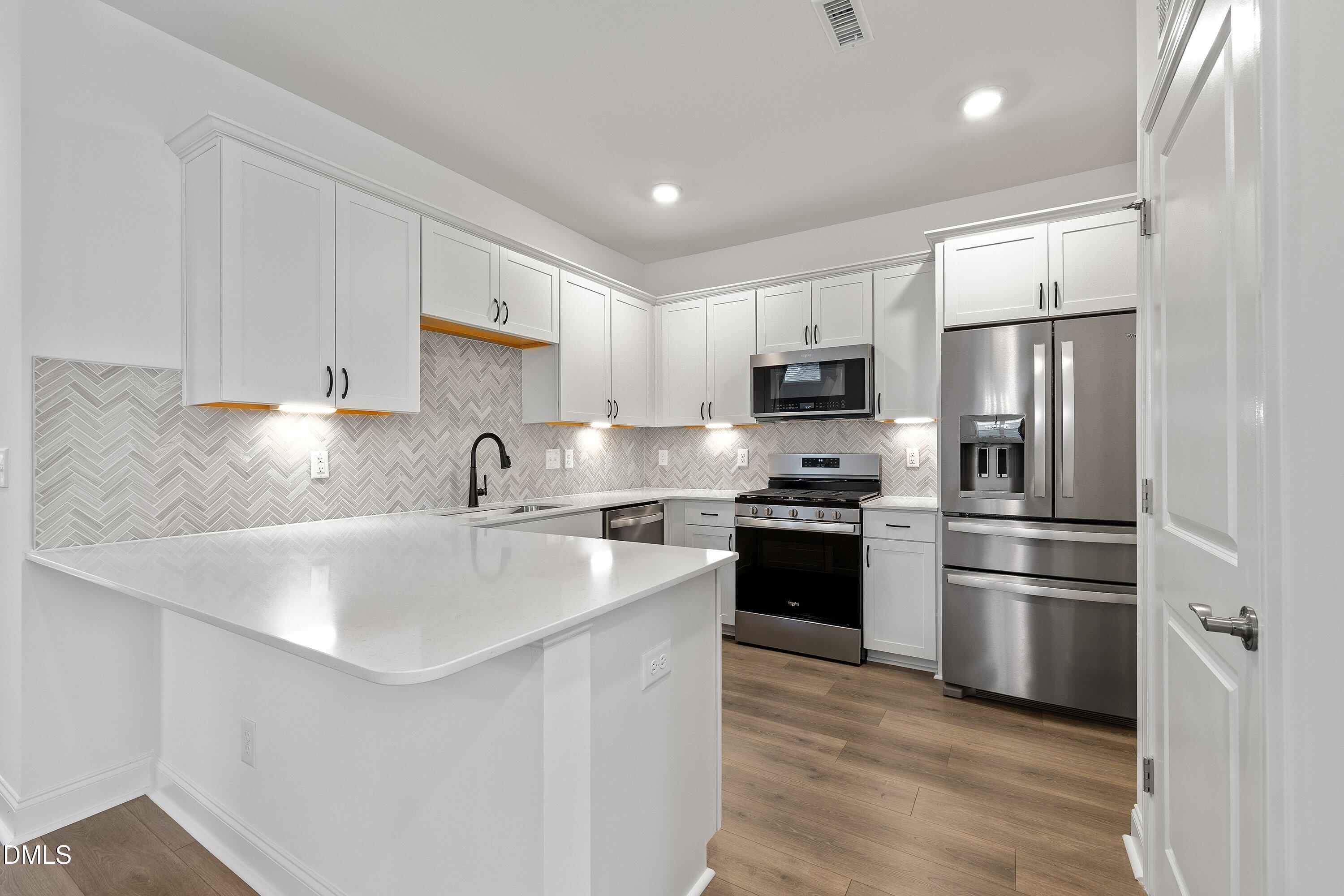 115 Swain Street Clayton, NC 27527 - Photo 11 of 46 a kitchen with stainless steel appliances granite countertop a sink stove and refrigerator