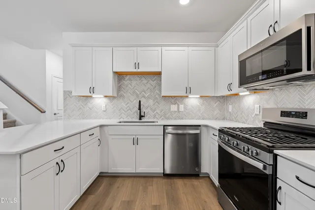 a kitchen with cabinets stainless steel appliances and a sink