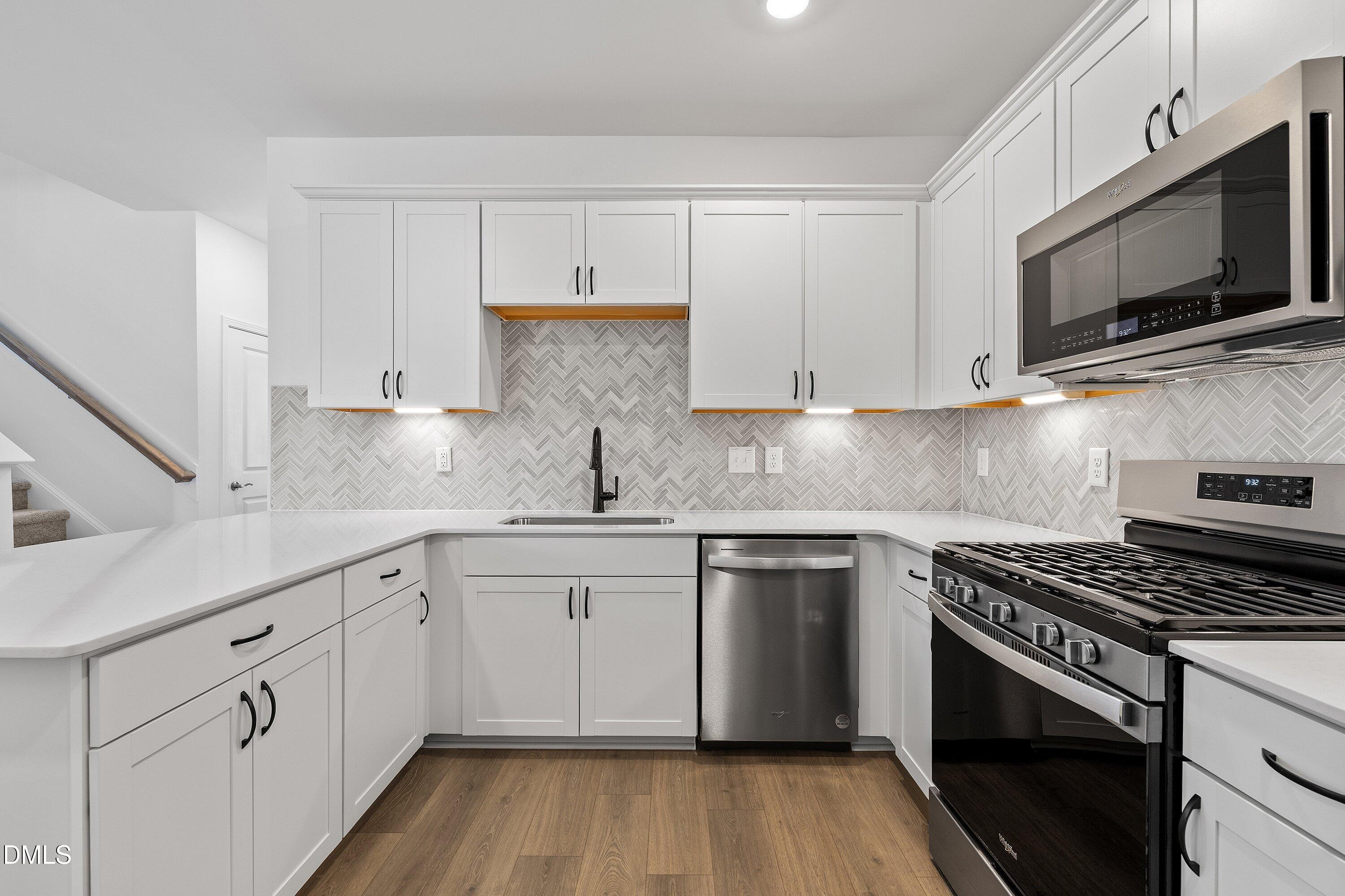 115 Swain Street Clayton, NC 27527 - Photo 12 of 46 a kitchen with cabinets stainless steel appliances and a sink