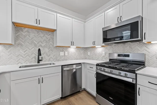 a kitchen with white cabinets and stainless steel appliances