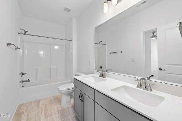 a bathroom with a sink double vanity granite toilet and shower