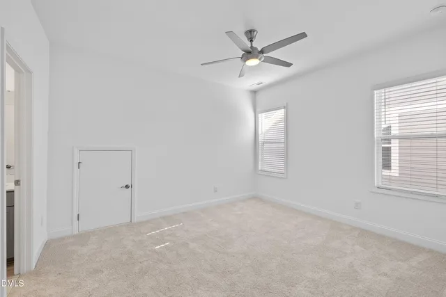 an empty room with a window and a fan