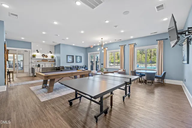 a living room with furniture pool table and a wooden floor