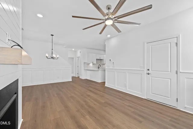 a view of a kitchen with wooden floor and a ceiling fan