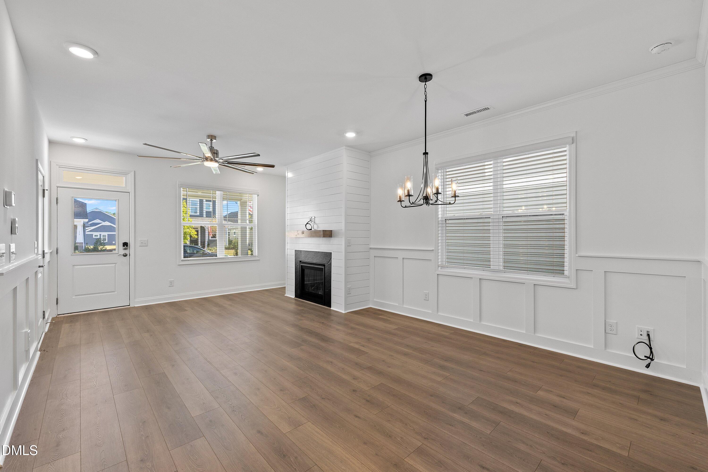 115 Swain Street Clayton, NC 27527 - Photo 8 of 46 an empty room with wooden floor fireplace and windows