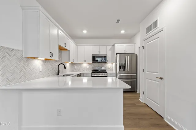 a kitchen with stainless steel appliances granite countertop a refrigerator sink and cabinets