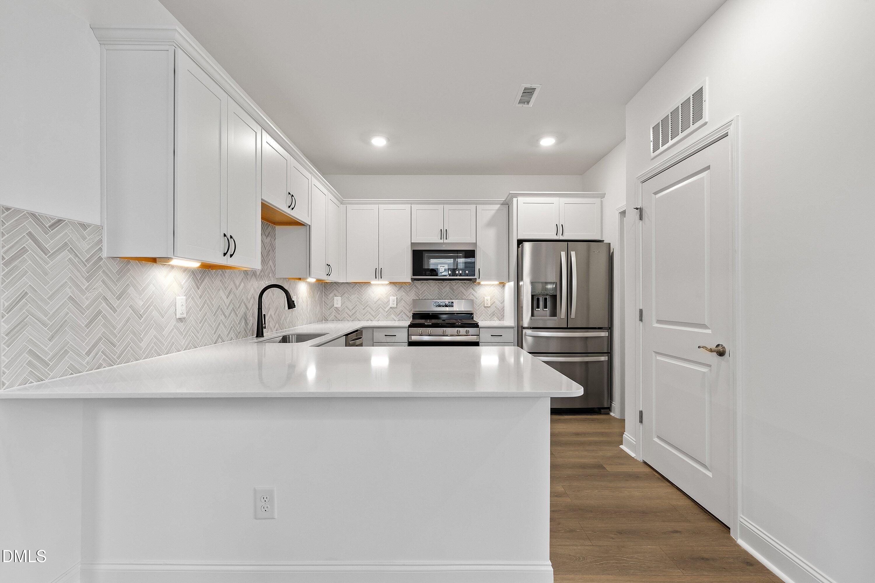 115 Swain Street Clayton, NC 27527 - Photo 10 of 46 a kitchen with stainless steel appliances granite countertop a refrigerator sink and cabinets