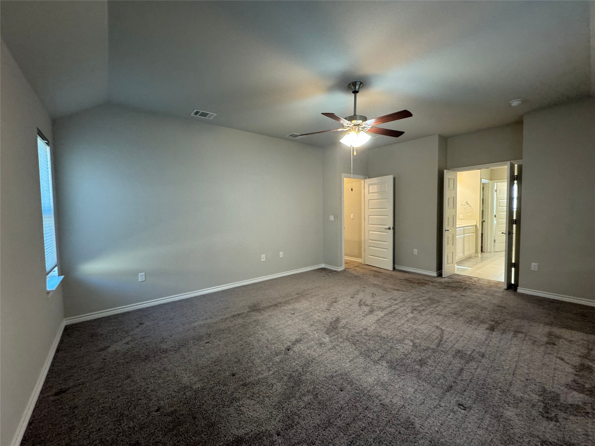 14100 McCoy Loop, Unit 1 Austin, TX 78717 - Photo 17 of 39 A spacious primary bedroom featuring a vaulted ceiling and direct access to an en-suite bathroom.