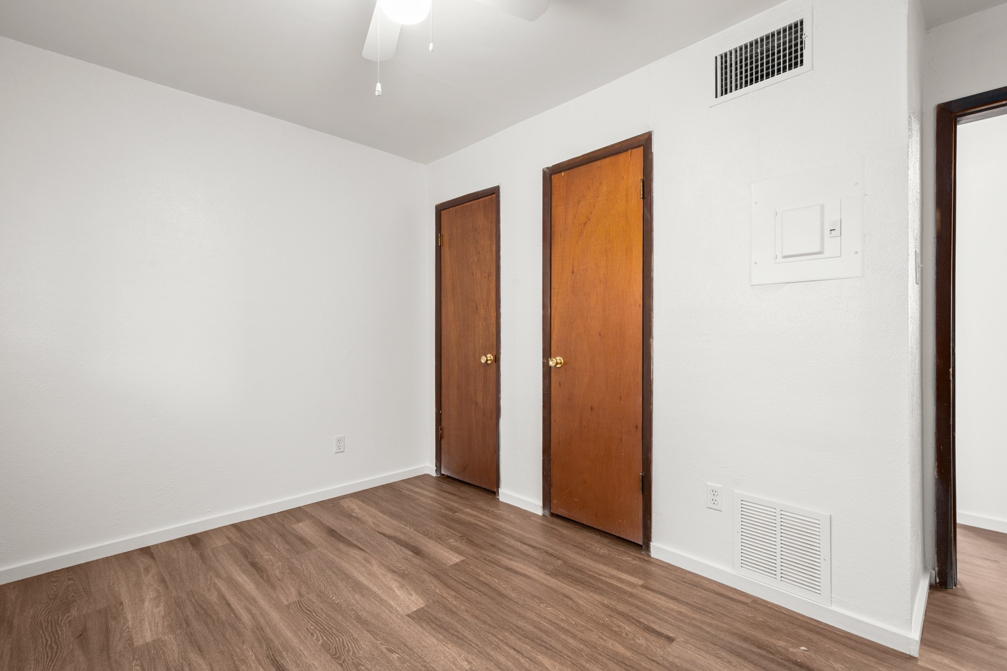 4205 Speedway, Unit 107 Austin, TX 78751 - Photo 13 of 15 Interior room featuring wood-finish flooring, white walls, and a white ceiling fan
