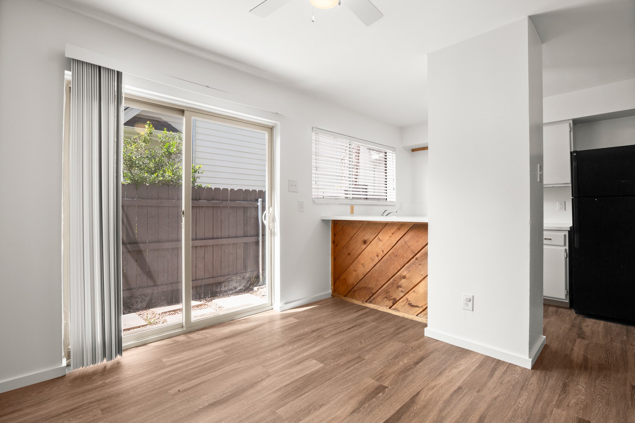 4205 Speedway, Unit 107 Austin, TX 78751 - Photo 3 of 15 Wood-finish flooring throughout, white walls, and a ceiling fan