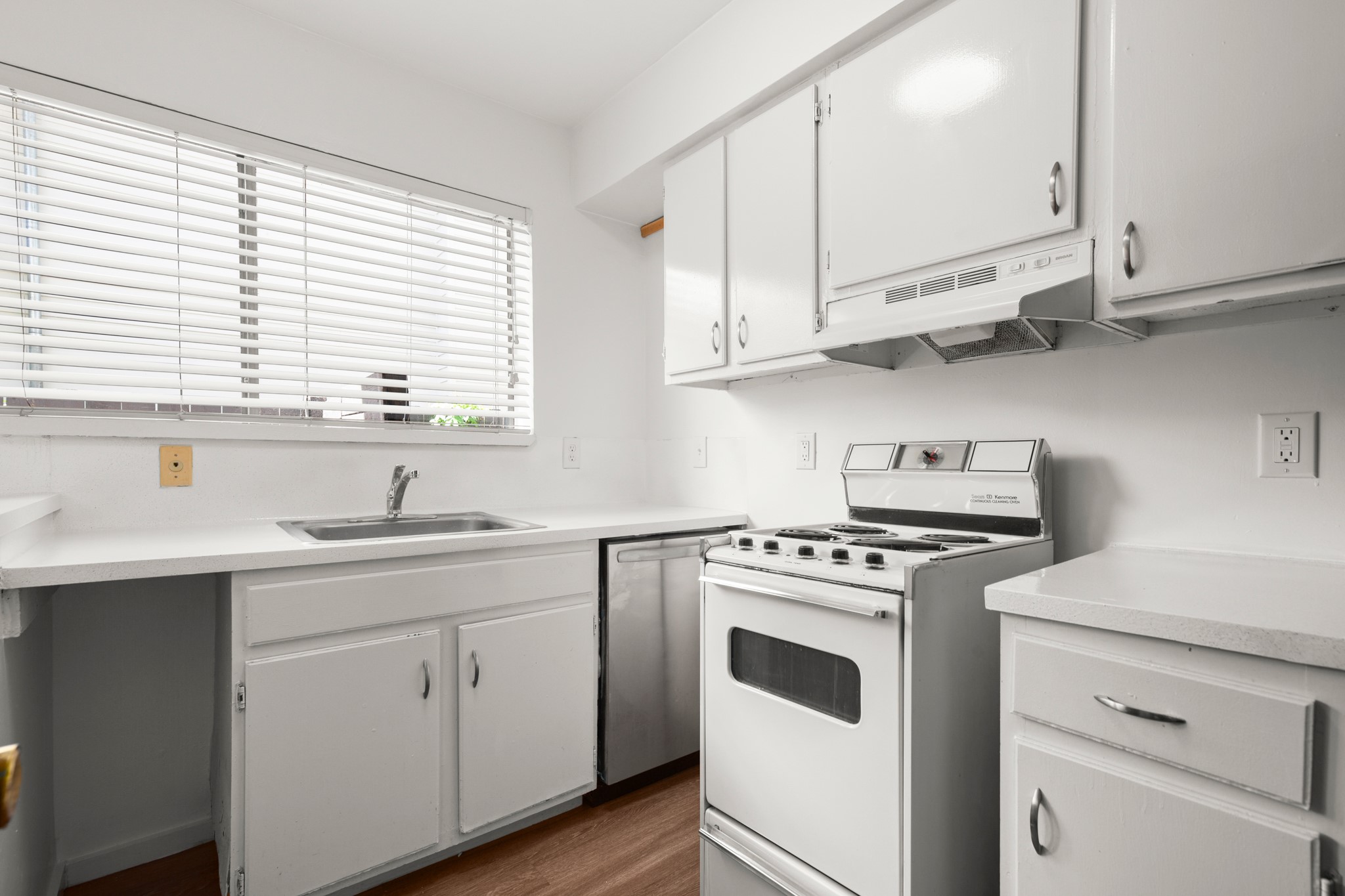 4205 Speedway, Unit 107 Austin, TX 78751 - Photo 7 of 15 Kitchen featuring white cabinetry, white countertops, stainless steel sink, white electric range, and a dishwasher