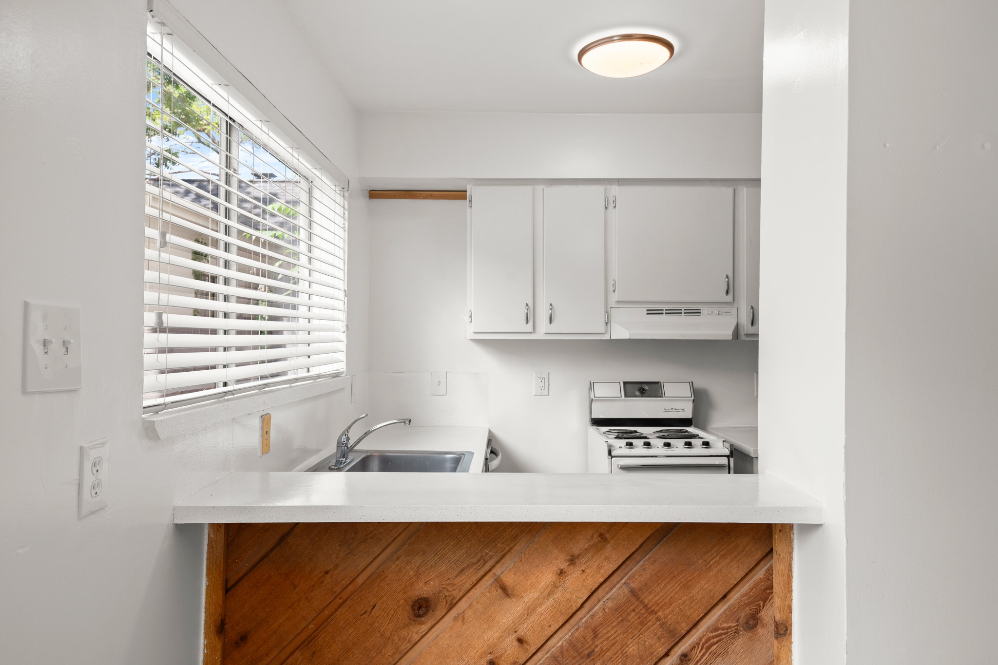 4205 Speedway, Unit 107 Austin, TX 78751 - Photo 8 of 15 Kitchen featuring white cabinetry, a stainless steel sink, and a white range