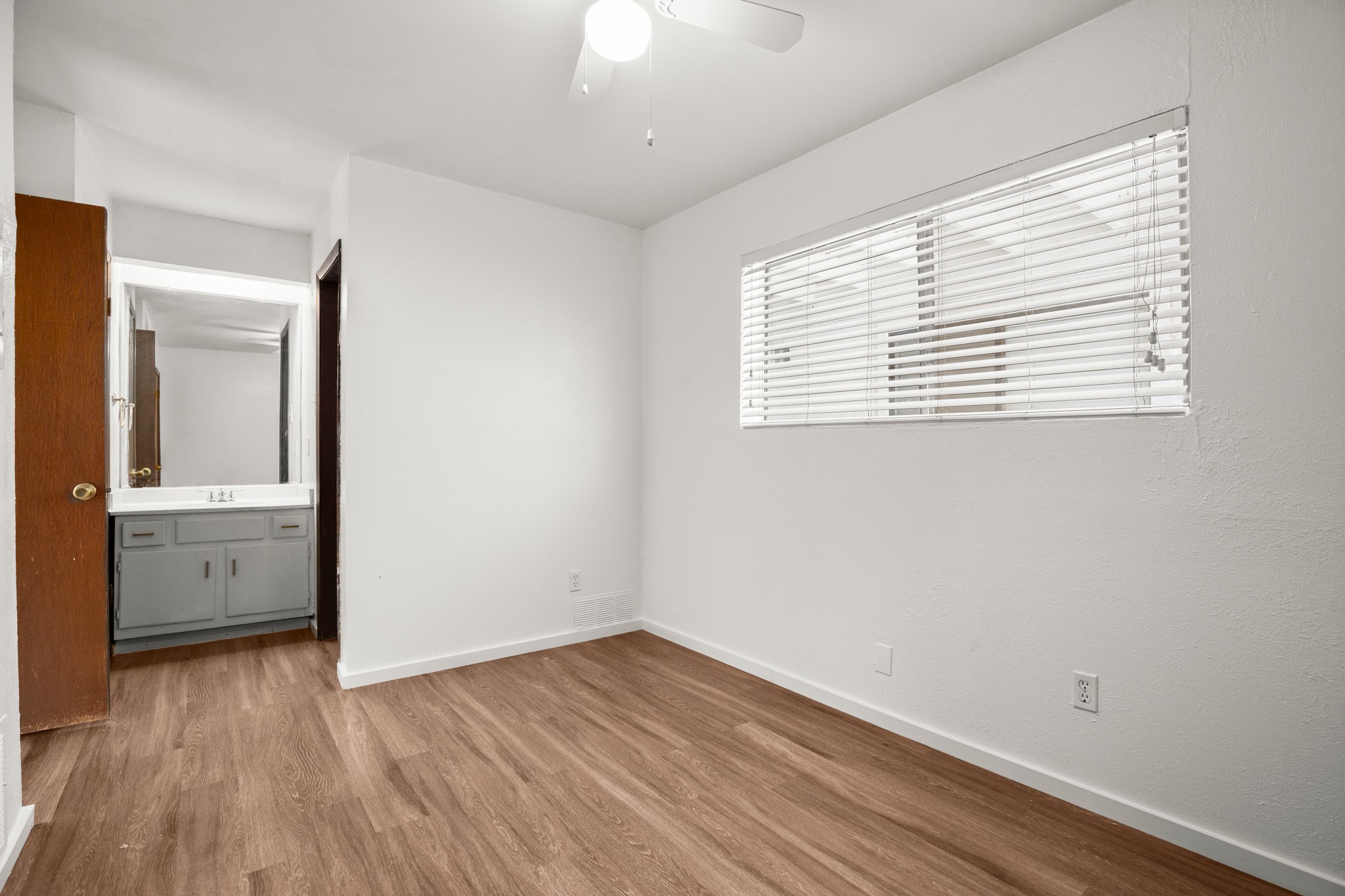 4205 Speedway, Unit 107 Austin, TX 78751 - Photo 10 of 15 Room featuring wood-finish flooring, a ceiling fan, and a window with blinds