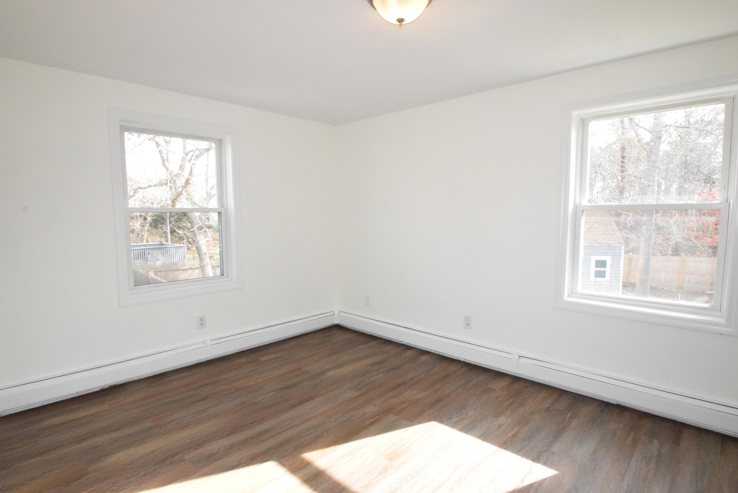 26 Ryder Road Harwich, MA 02645 - Photo 11 of 34 an empty room with wooden floor and windows