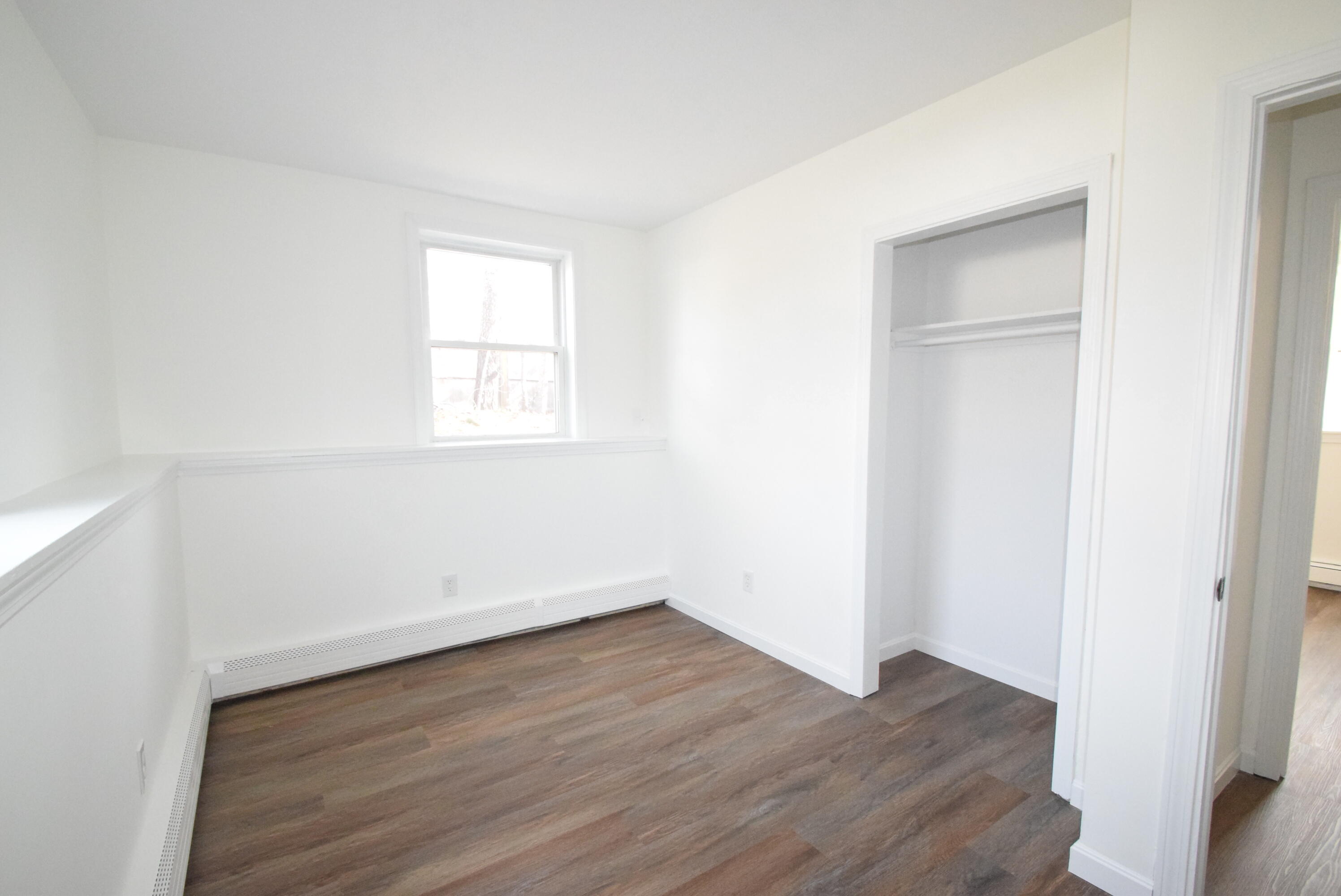 26 Ryder Road Harwich, MA 02645 - Photo 20 of 34 an empty room with wooden floor and windows