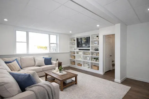 a living room with furniture and a book shelf