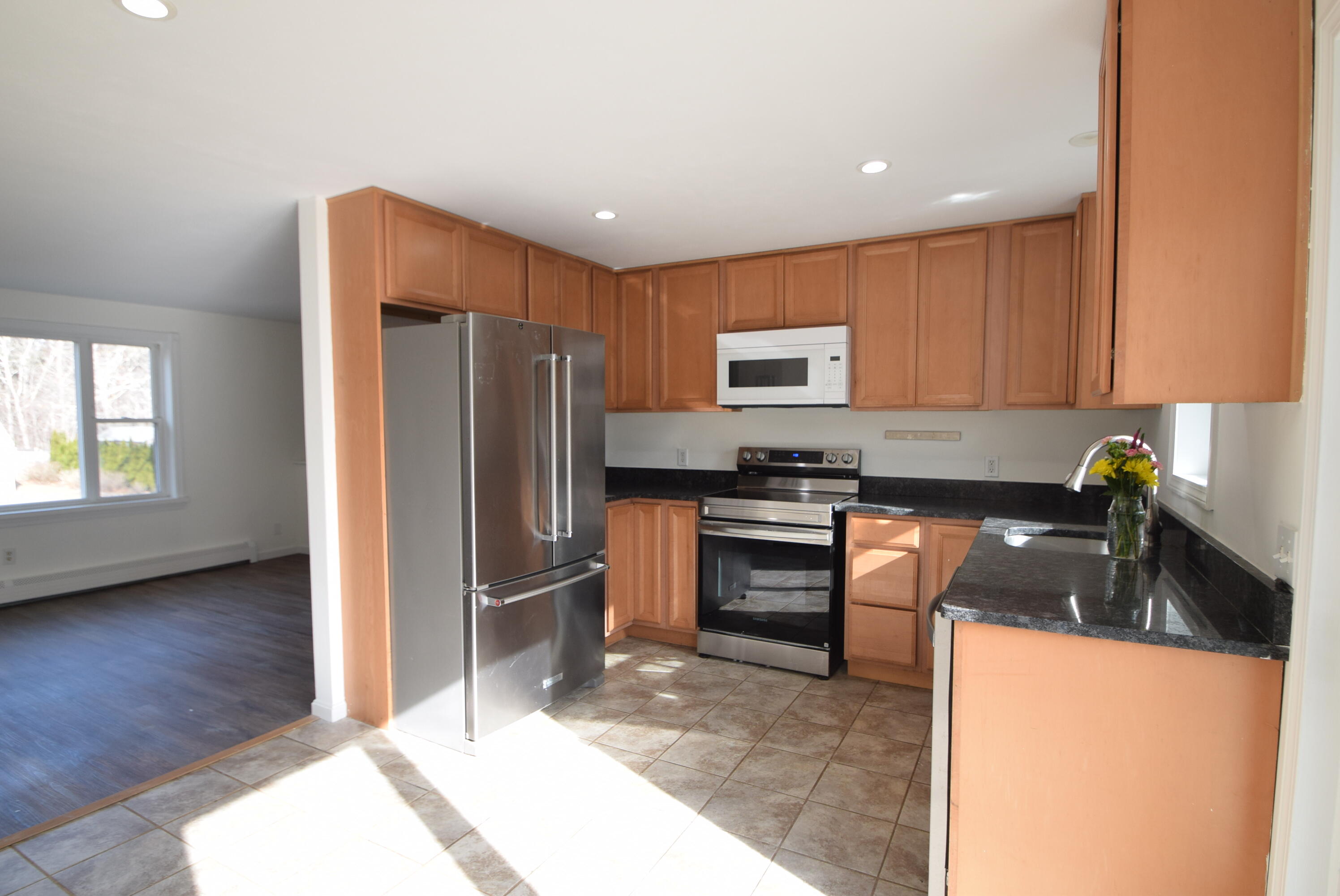 26 Ryder Road Harwich, MA 02645 - Photo 4 of 34 a kitchen with granite countertop a refrigerator and a stove top oven