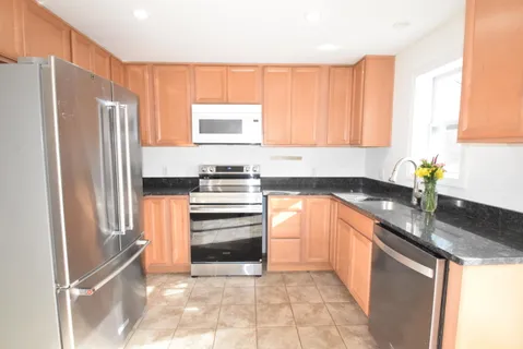 a kitchen with granite countertop a refrigerator and a sink
