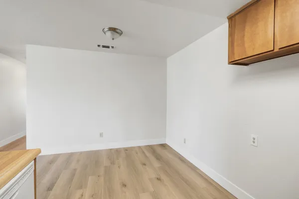 a view of a room with wooden floor and a window