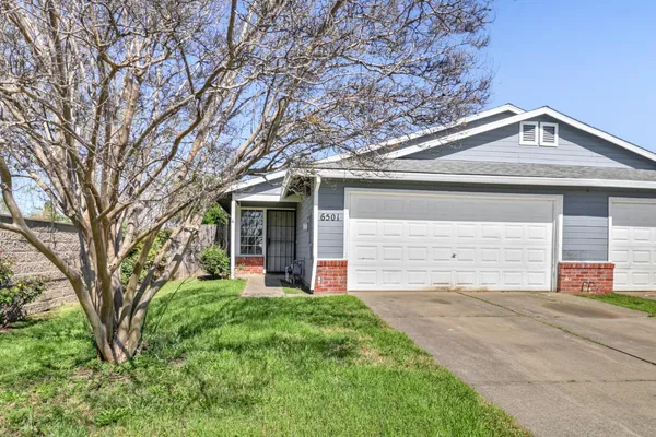 front view of a house with a yard and an trees
