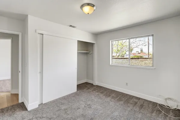 an empty room with windows & closet