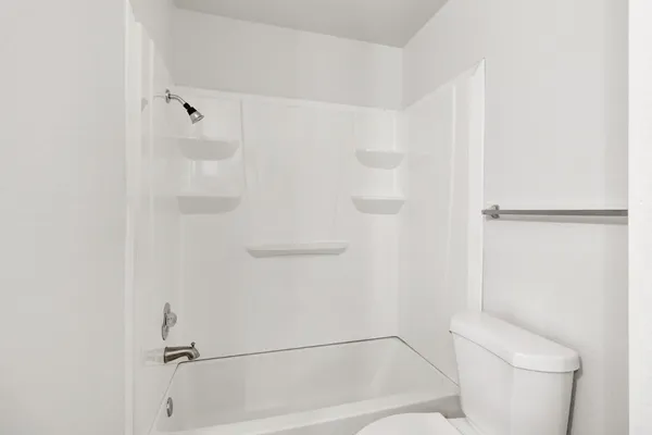 a bathroom with a toilet and a shower