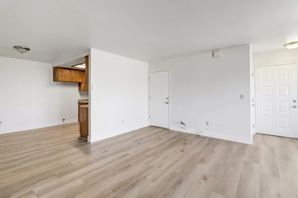 a view of an empty room with wooden floor