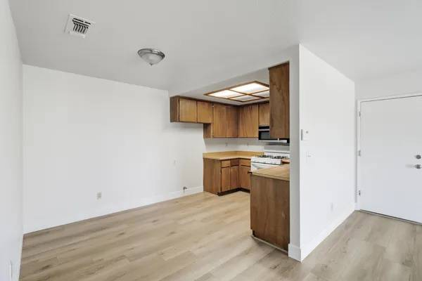 a kitchen with a sink cabinets and wooden floor