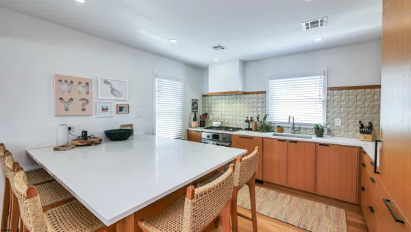 a kitchen with stainless steel appliances a table chairs sink and cabinets