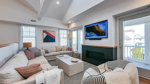 a living room with furniture a flat screen tv and a fireplace