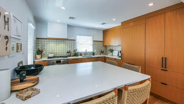 a large kitchen with kitchen island a large counter top space a sink stainless steel appliances and cabinets