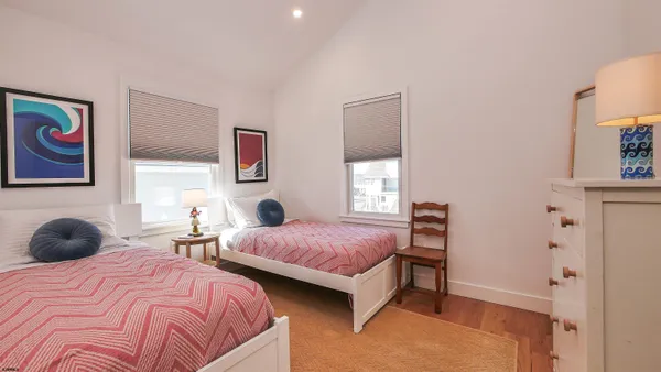a bedroom with two bed and a window