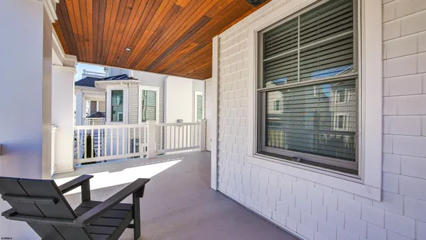 a view of a porch with furniture and floor to ceiling window