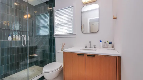 a bathroom with a granite countertop sink toilet and mirror