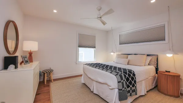 a bedroom with a bed a mirror and a window