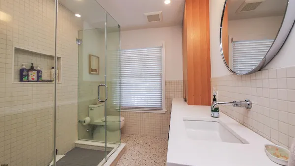 a bathroom with a tub a sink and a large mirror