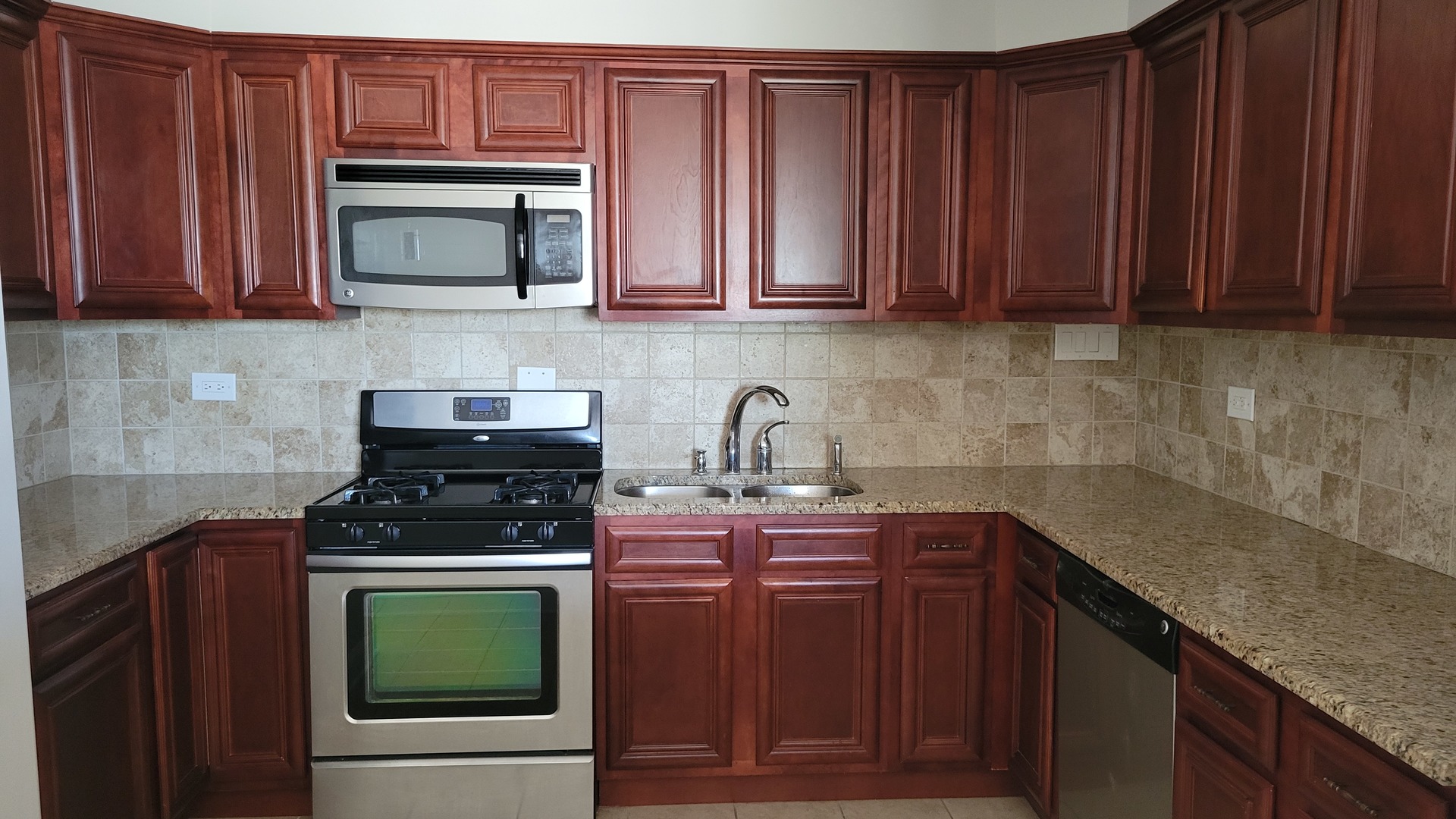 9001 West Golf Road, Unit 4B Des Plaines, IL 60016 - Photo 7 of 21 a kitchen with stainless steel appliances granite countertop wooden cabinets a stove top oven a sink and dishwasher
