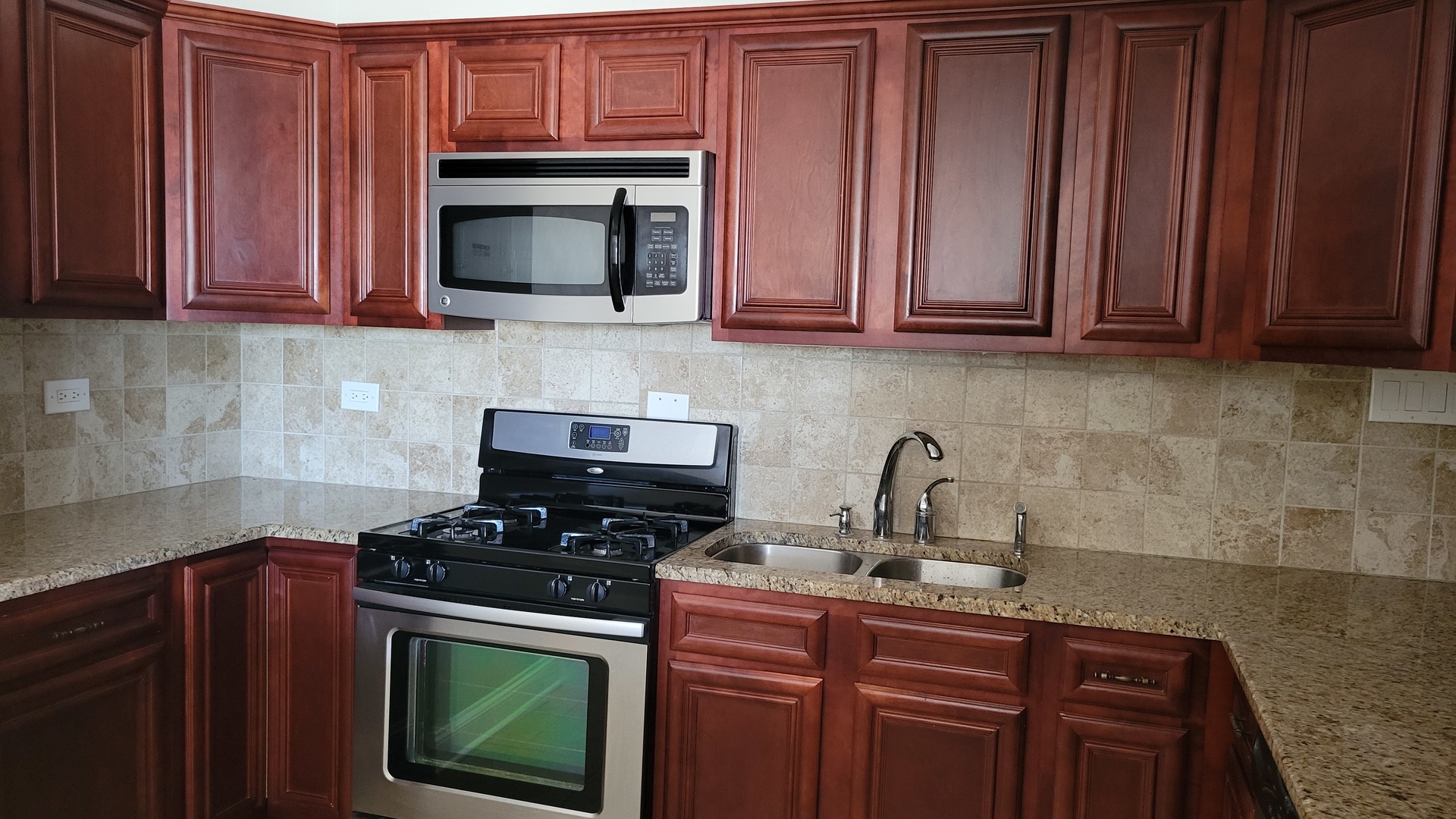 9001 West Golf Road, Unit 4B Des Plaines, IL 60016 - Photo 9 of 21 a kitchen with granite countertop wood cabinets and stainless steel appliances