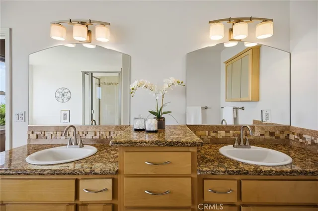 a bathroom with a granite countertop tub shower and a sink