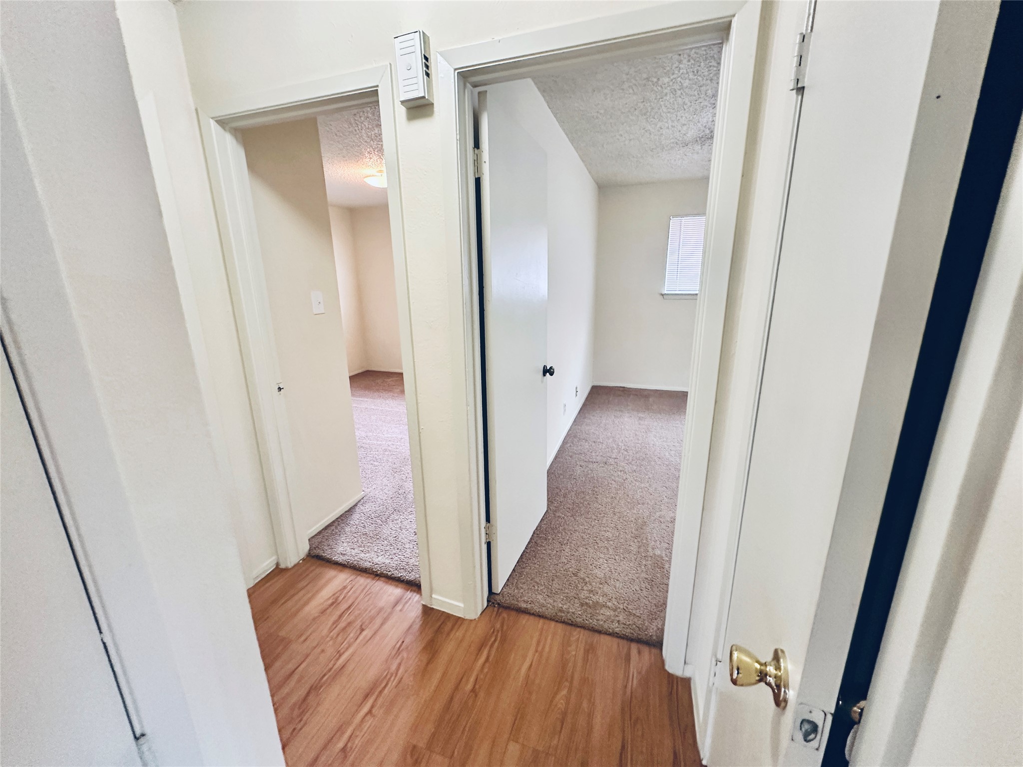 12504 Tree Line Drive, Unit B Austin, TX 78729 - Photo 12 of 22 Hall with a textured ceiling and light wood finished floors