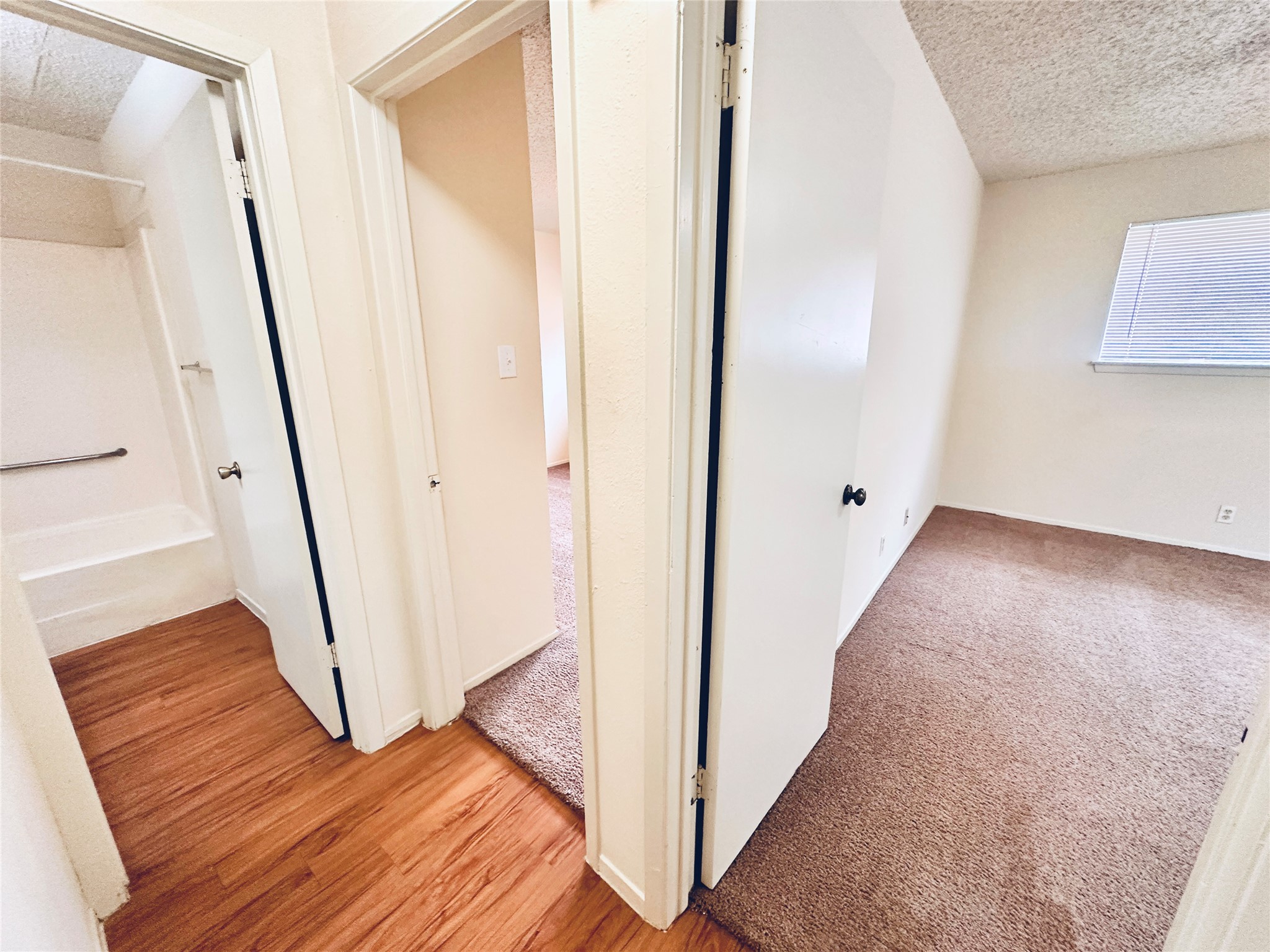 12504 Tree Line Drive, Unit B Austin, TX 78729 - Photo 14 of 22 Hallway with a textured ceiling and light wood-style floors