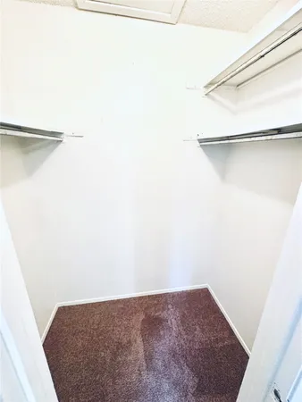 an empty room with chandelier fan and windows