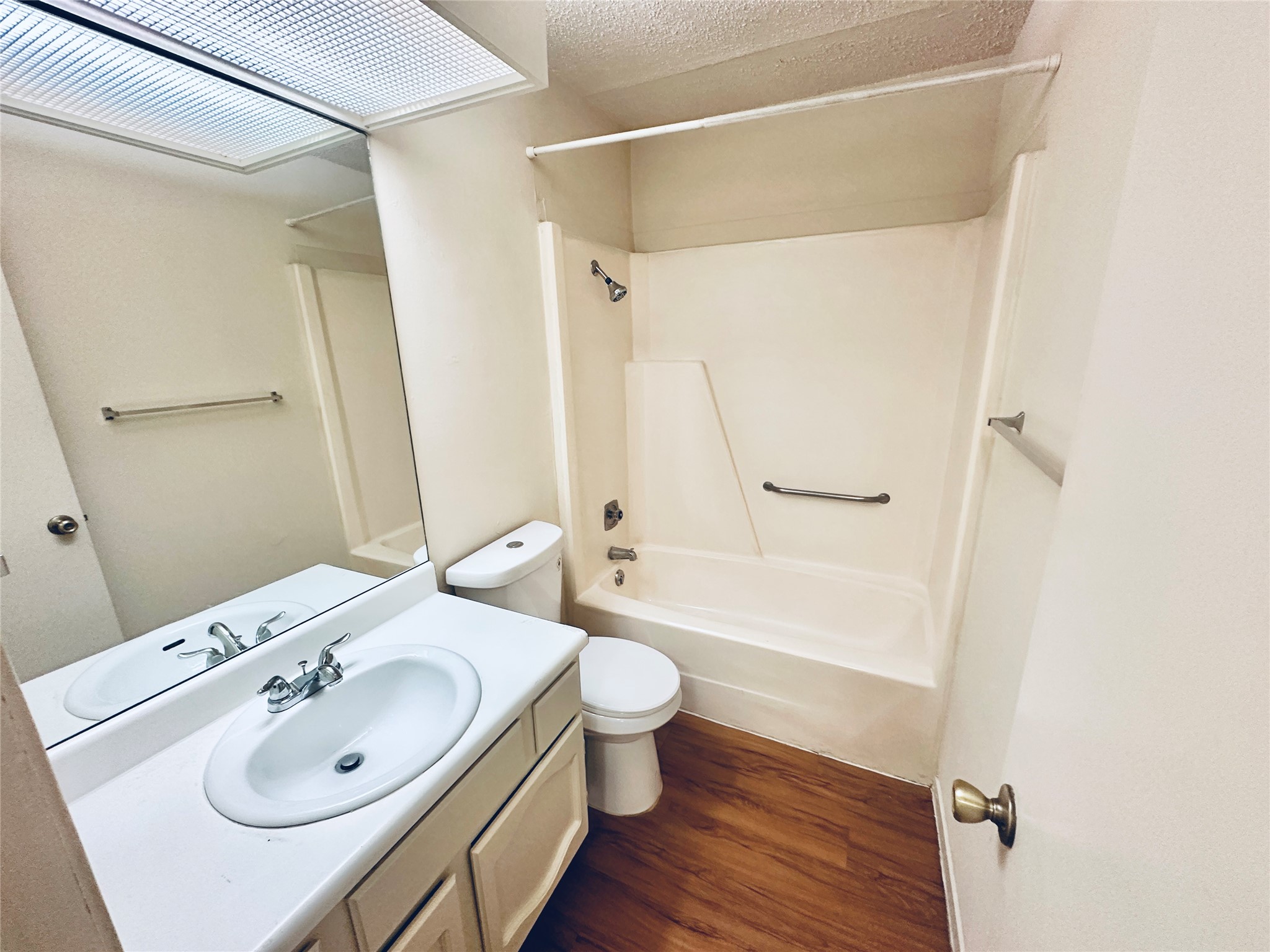 12504 Tree Line Drive, Unit B Austin, TX 78729 - Photo 21 of 22 Bathroom featuring vanity, a textured ceiling, bathing tub / shower combination, and dark wood finished floors