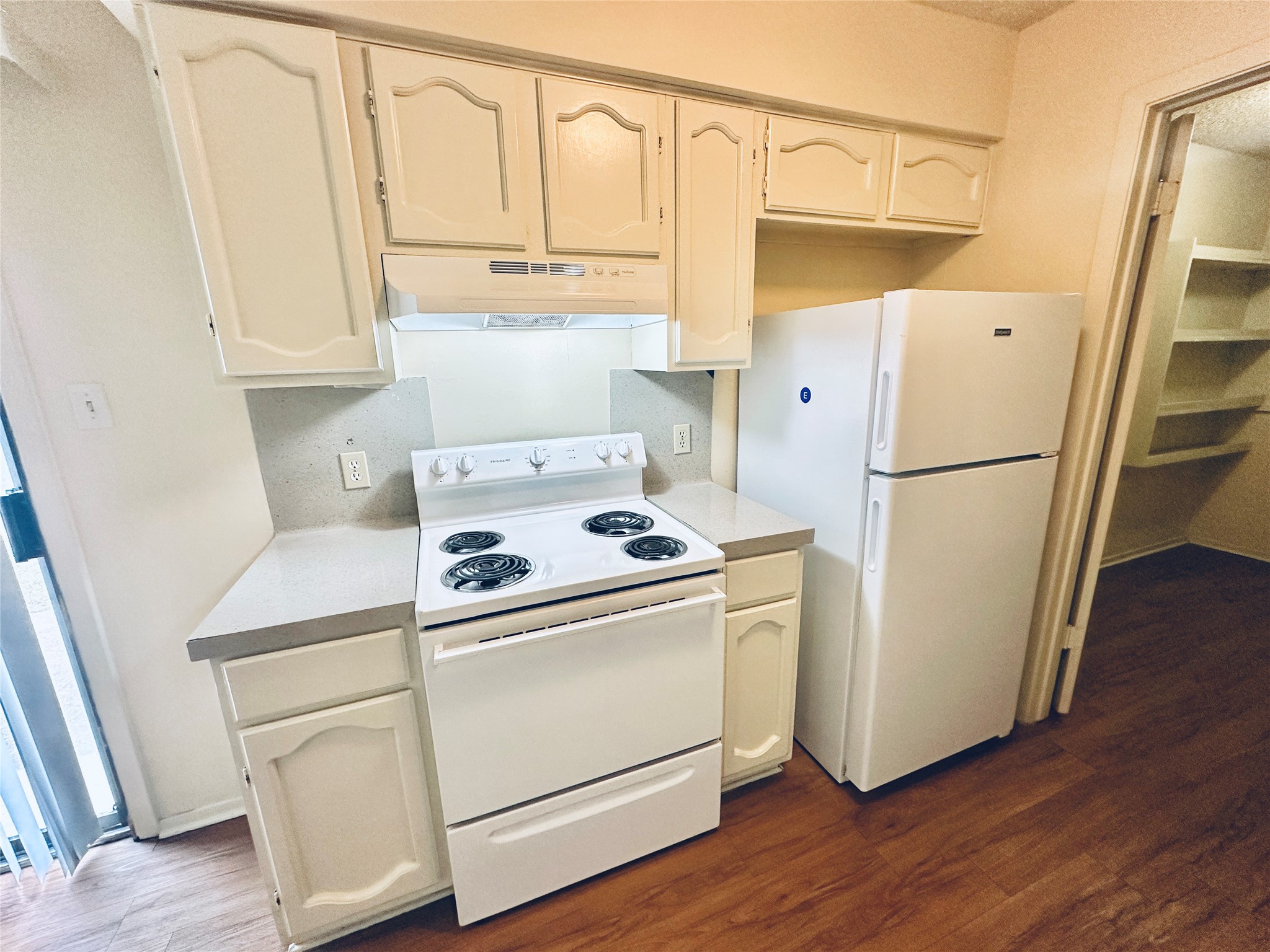 12504 Tree Line Drive, Unit B Austin, TX 78729 - Photo 9 of 22 Kitchen with white appliances, light countertops, and dark wood-type flooring