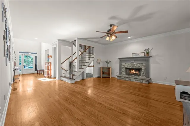 a view of an empty room with wooden floor a fireplace and a window